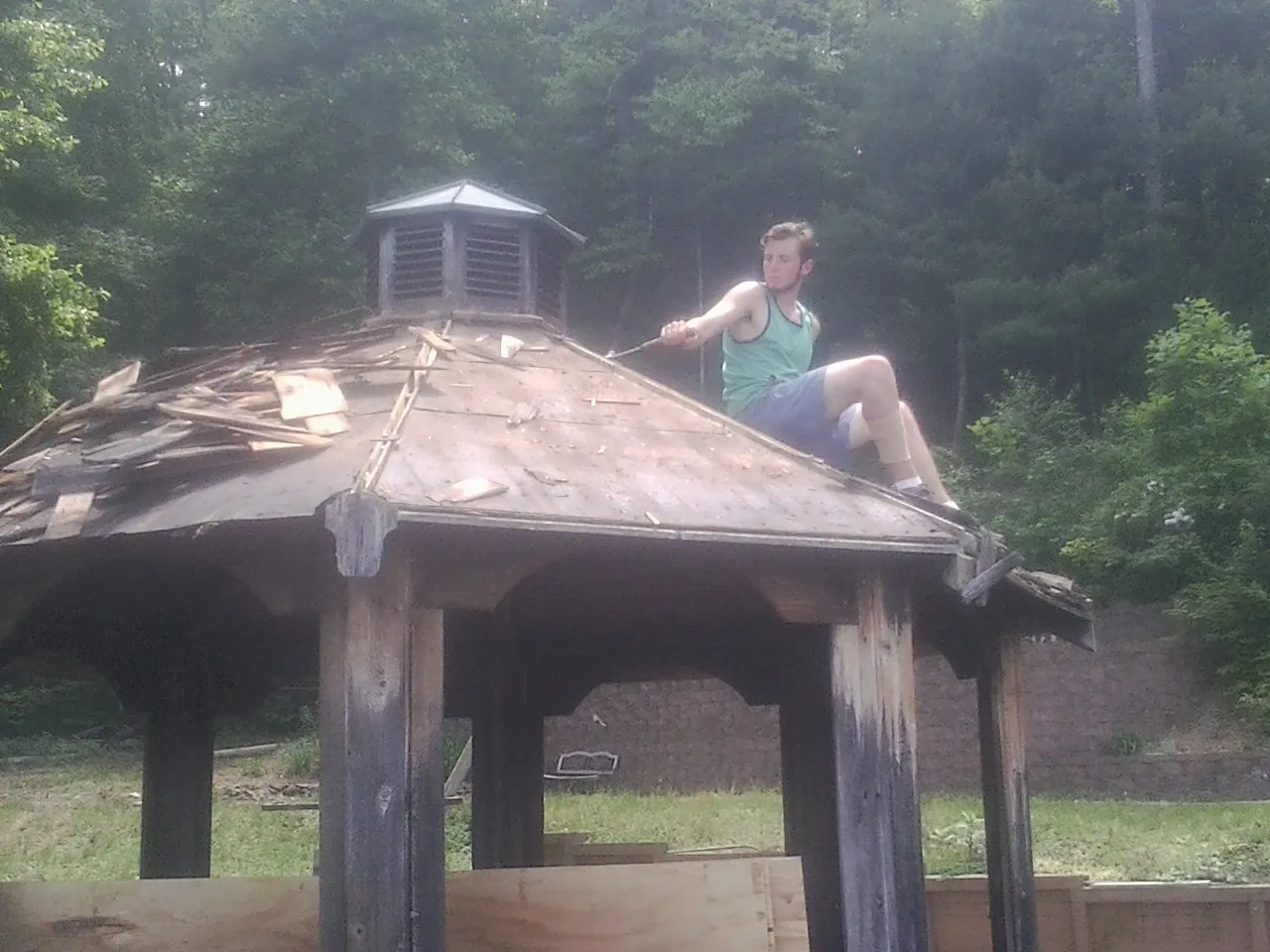 Tearing the old roof off a wooden gazebo before new shakes in Mountain View