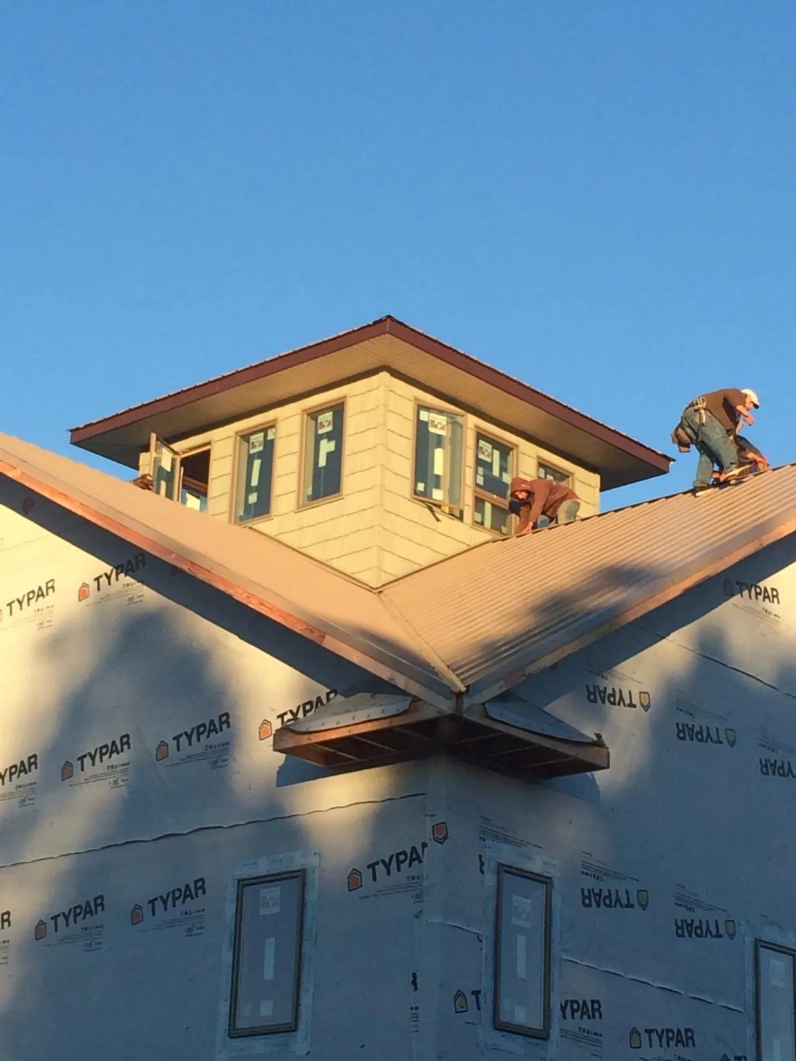 Roofers working around a rooftop cupola on a new metal roof at sunset — Roof Waterproofing in Mountain View by Roofing Brothers